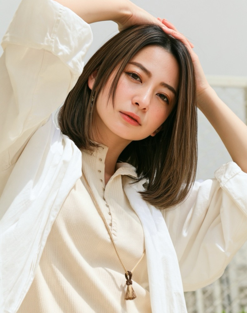 白いシャツを羽織り髪に手を添える、艶のあるストレートミディアム