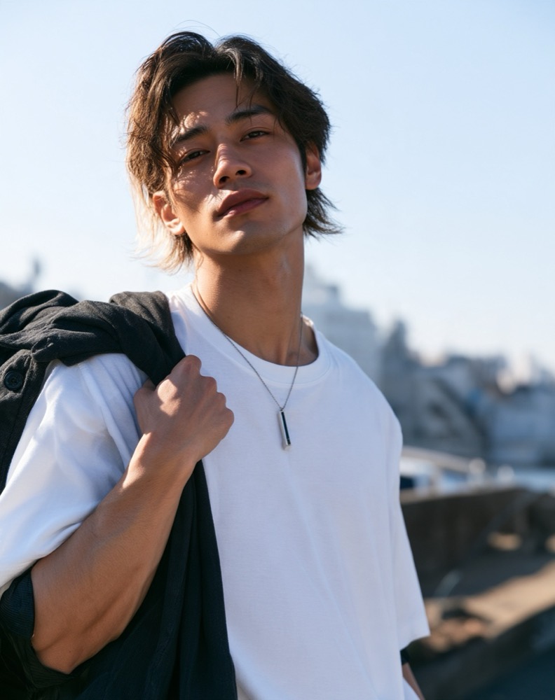 白いTシャツに黒いジャケットを肩にかけた男性、柔らかく流れる黒髪のミディアム